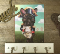 Wall art with a dog dressed as Napoleon, 'Laugh' sign, and decorative hooks.
