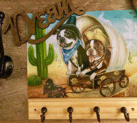 Decorative wall hook with painting of two dogs in a covered wagon.