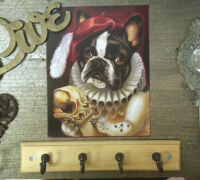 Decorative wall art featuring a dog portrait and vintage hooks.