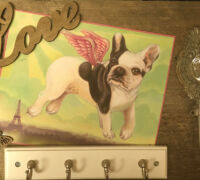 Wall decoration with a flying French bulldog illustration, a wooden 'Love' sign, and a decorative hook.